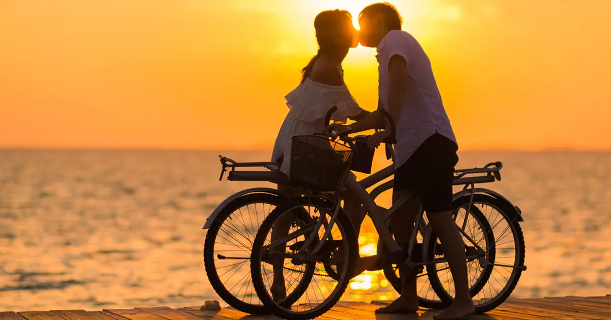 Couple on bikes kissing.